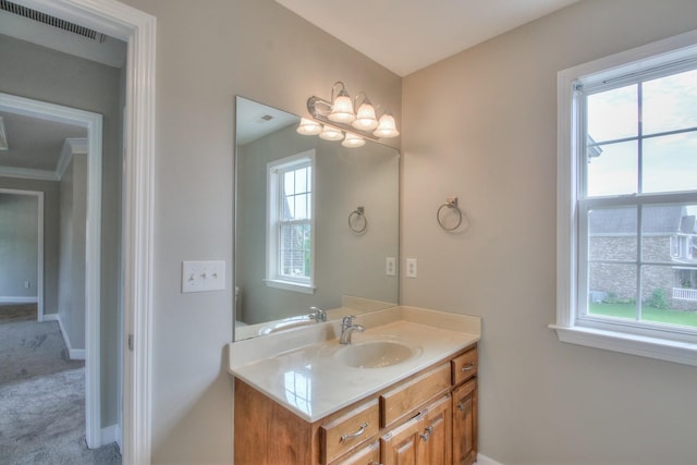 bathroom featuring vanity, plenty of natural light, crown molding, and a chandelier