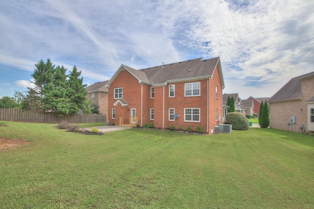 rear view of house featuring a yard, a patio, and central air condition unit