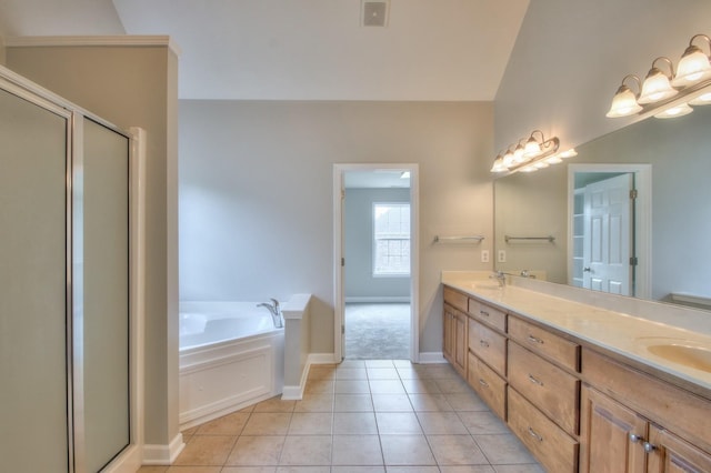 bathroom featuring plus walk in shower, vanity, and tile patterned floors