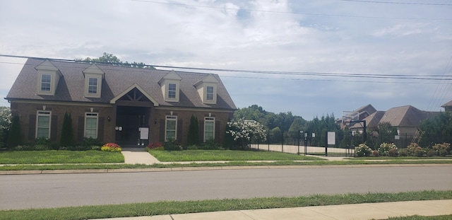 new england style home featuring a front lawn