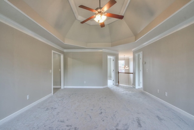 spare room with ceiling fan with notable chandelier, a raised ceiling, carpet floors, and crown molding