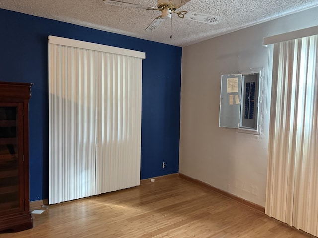 unfurnished room featuring ceiling fan, a textured ceiling, and light wood-type flooring