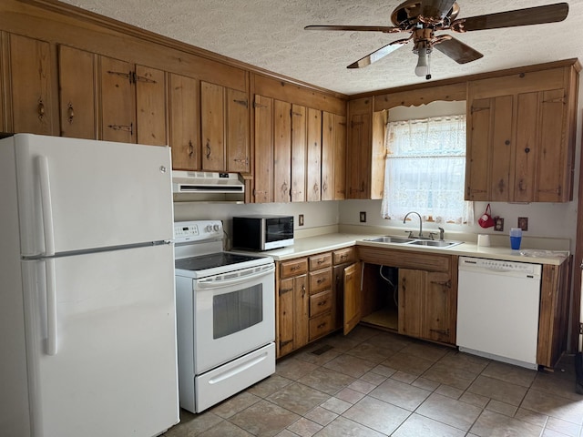 kitchen featuring a textured ceiling, ceiling fan, sink, and white appliances