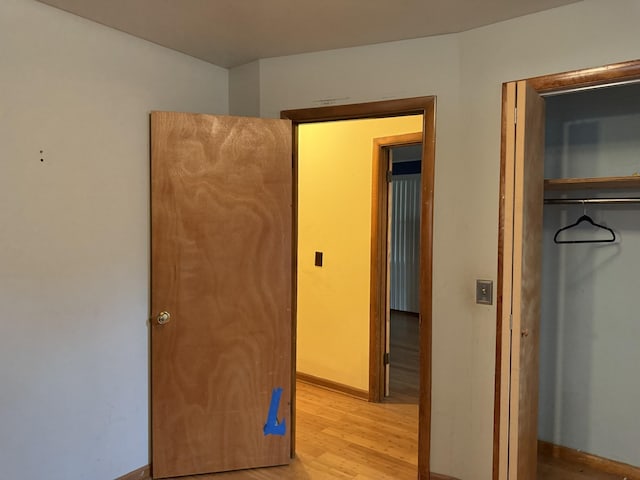 unfurnished bedroom with a closet and light hardwood / wood-style floors