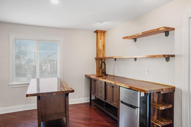 bar with a wealth of natural light, sink, refrigerator, and wood counters