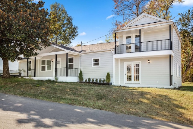 view of front facade with a porch, a balcony, and a front lawn