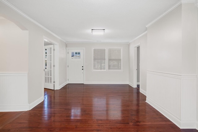 foyer entrance with a textured ceiling, dark hardwood / wood-style flooring, and ornamental molding