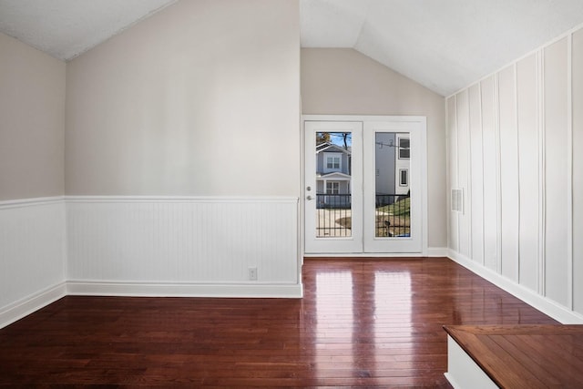 empty room featuring dark wood-type flooring and vaulted ceiling