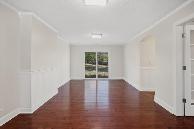 empty room with dark wood-type flooring, a textured ceiling, and ornamental molding