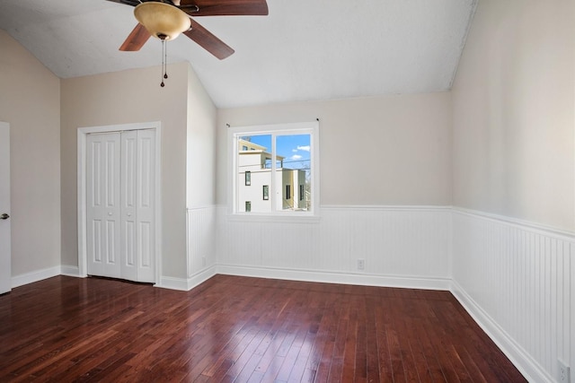 unfurnished bedroom with a closet, dark hardwood / wood-style floors, ceiling fan, and lofted ceiling