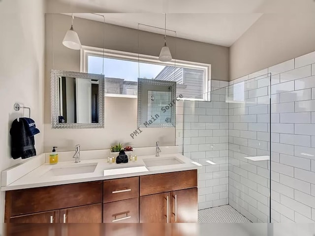 bathroom with a tile shower and vanity