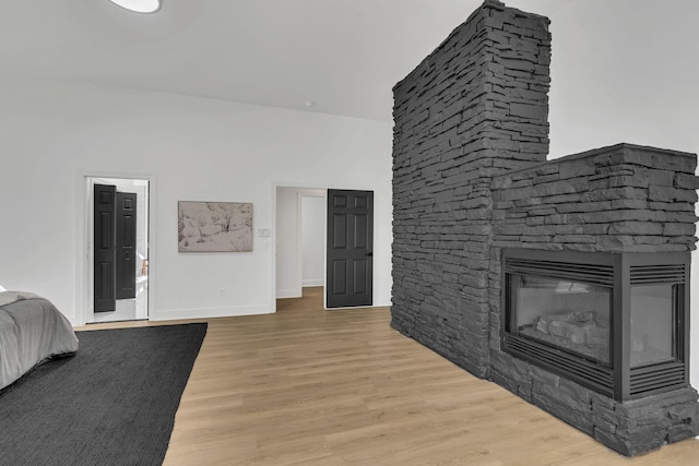 bedroom featuring a fireplace and light wood-type flooring