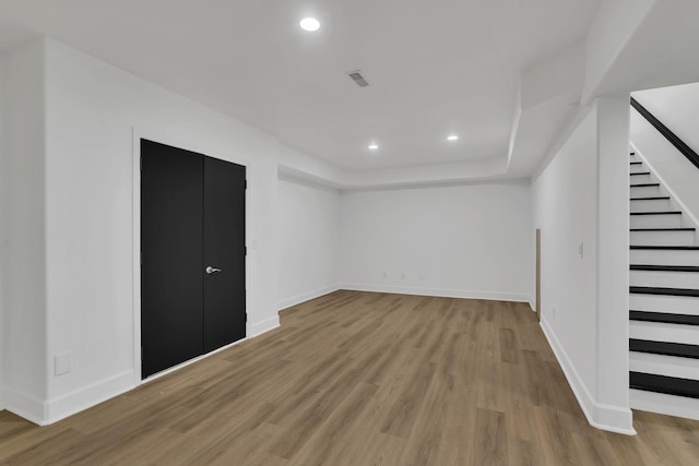 interior space featuring light wood-type flooring and a tray ceiling