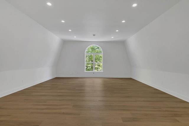 spare room with vaulted ceiling and dark wood-type flooring