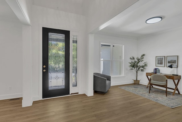 entrance foyer with dark hardwood / wood-style floors and ornamental molding