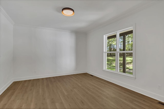 empty room with hardwood / wood-style floors and ornamental molding