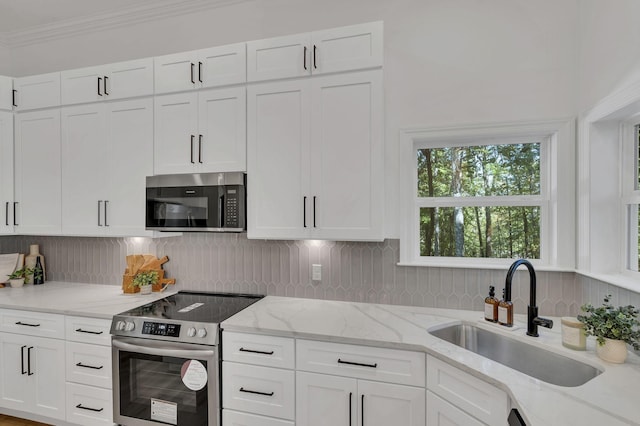 kitchen featuring light stone counters, sink, white cabinets, and stainless steel appliances