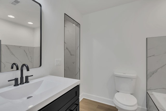 bathroom with vanity, hardwood / wood-style flooring, and toilet