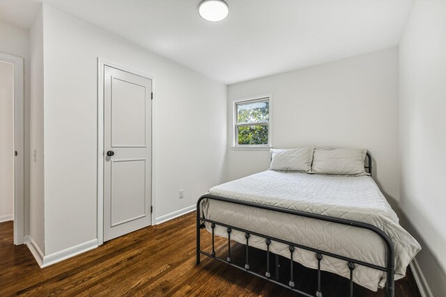 bedroom with dark wood-type flooring