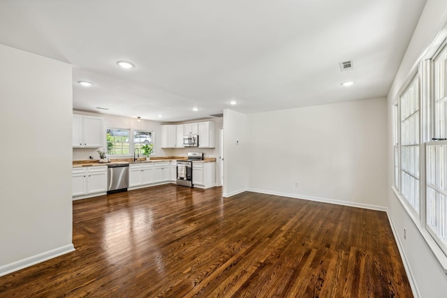 unfurnished living room featuring dark wood-type flooring and sink