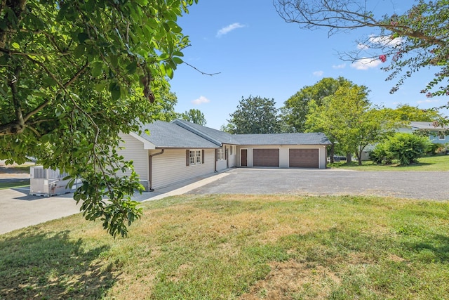 single story home featuring a garage and a front lawn