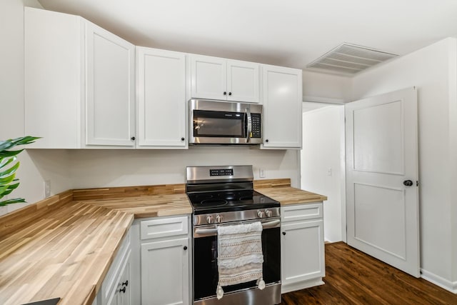 kitchen with white cabinets, wood counters, stainless steel appliances, and dark wood-type flooring