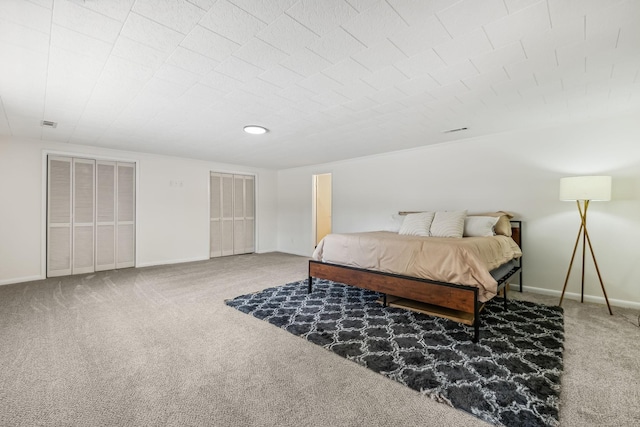 bedroom featuring carpet floors and multiple closets