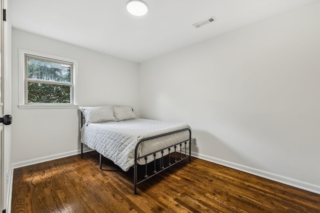 bedroom with dark hardwood / wood-style flooring