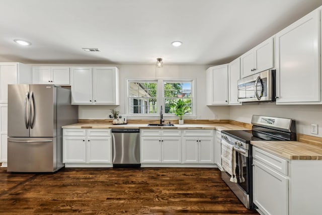 kitchen with stainless steel appliances, white cabinetry, and sink