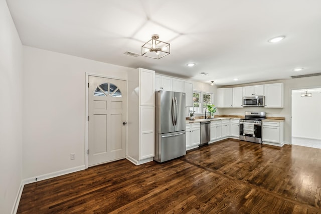 kitchen with sink, stainless steel appliances, dark hardwood / wood-style floors, a notable chandelier, and white cabinets