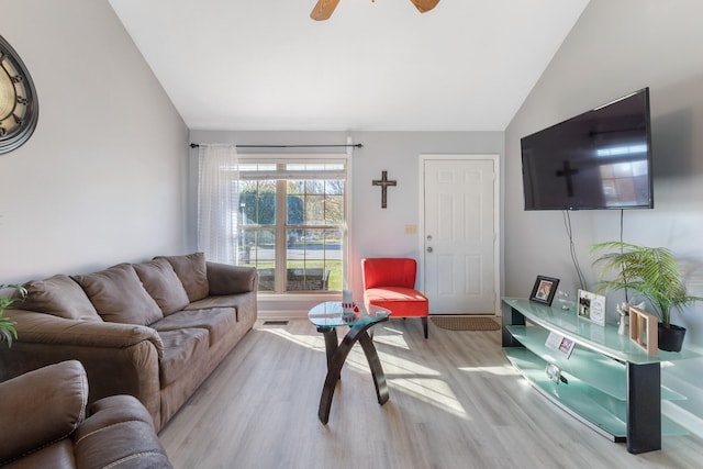 living room featuring ceiling fan, light hardwood / wood-style floors, and vaulted ceiling