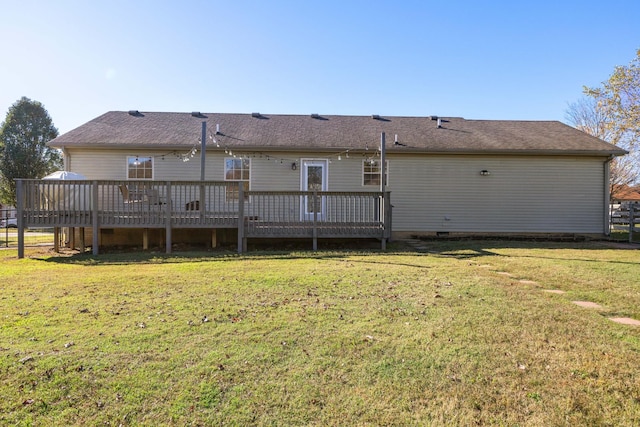 rear view of property with a wooden deck and a yard