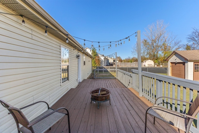 deck featuring an outdoor fire pit and an outdoor structure