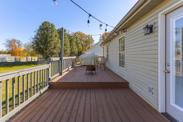 wooden terrace with area for grilling and a lawn