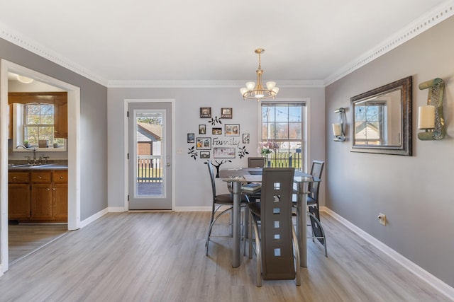 dining area featuring a chandelier, light hardwood / wood-style flooring, plenty of natural light, and sink