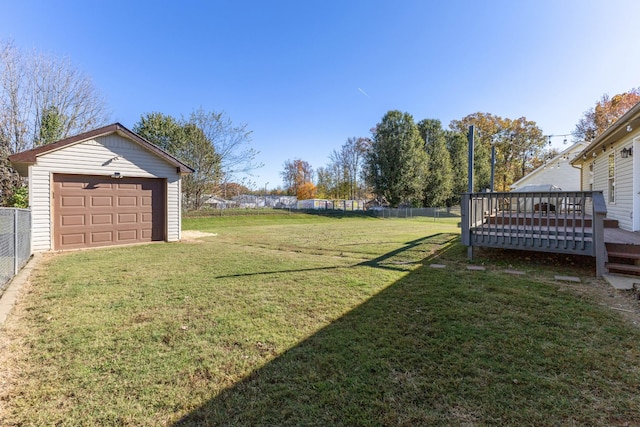 view of yard featuring an outbuilding, a garage, and a deck