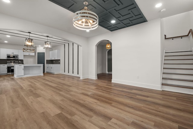 unfurnished living room with light hardwood / wood-style flooring and an inviting chandelier