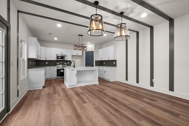 kitchen with decorative light fixtures, an island with sink, appliances with stainless steel finishes, a notable chandelier, and white cabinetry