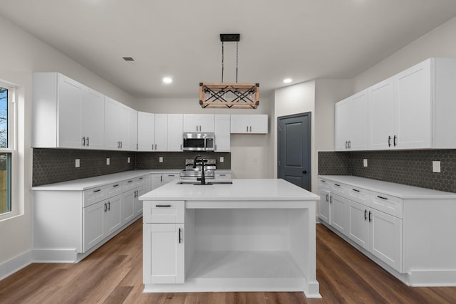 kitchen with a center island with sink, white cabinets, sink, and appliances with stainless steel finishes