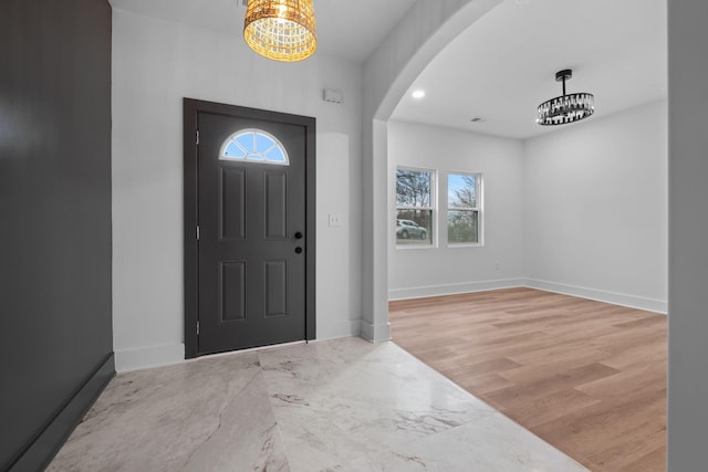 entrance foyer with light hardwood / wood-style floors and an inviting chandelier