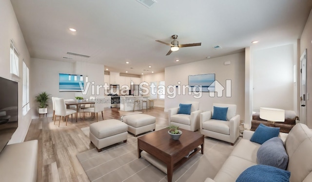 living room featuring ceiling fan and light hardwood / wood-style flooring