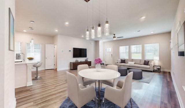 dining room with ceiling fan and light hardwood / wood-style floors