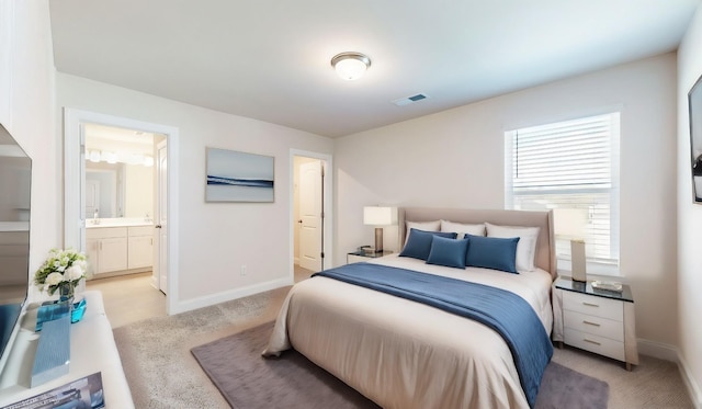 bedroom featuring light carpet and connected bathroom