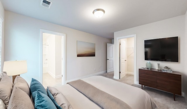 bedroom with light carpet and ensuite bath