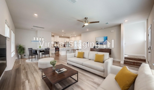 living room featuring ceiling fan and light hardwood / wood-style floors