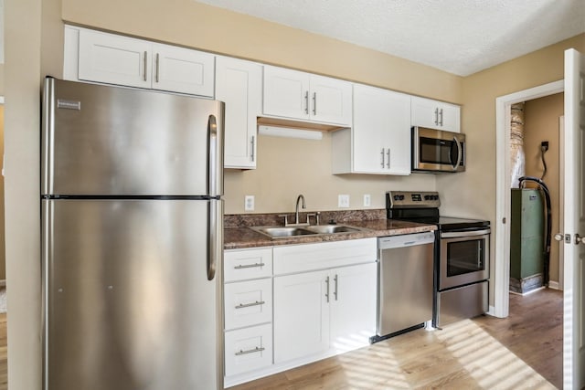 kitchen featuring light hardwood / wood-style floors, sink, white cabinetry, and stainless steel appliances