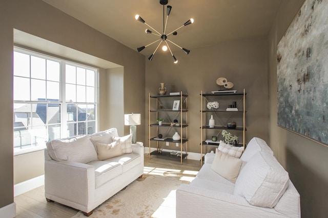 living room featuring a healthy amount of sunlight, light hardwood / wood-style flooring, and a notable chandelier