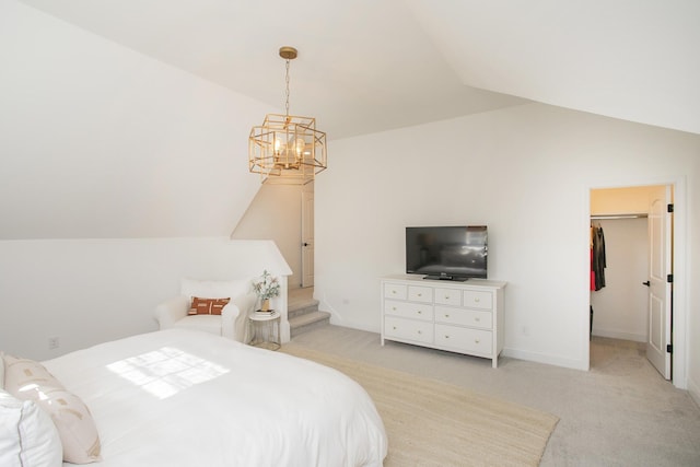 bedroom with vaulted ceiling, light colored carpet, a walk in closet, and a closet