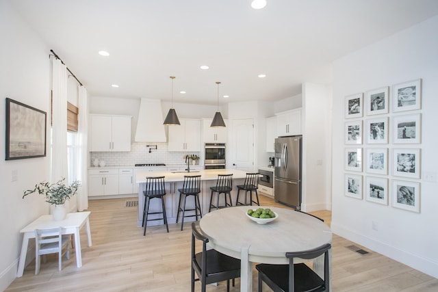 dining space with light wood-type flooring and sink