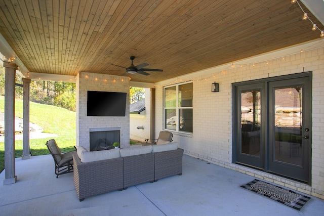 view of patio with an outdoor living space with a fireplace and ceiling fan